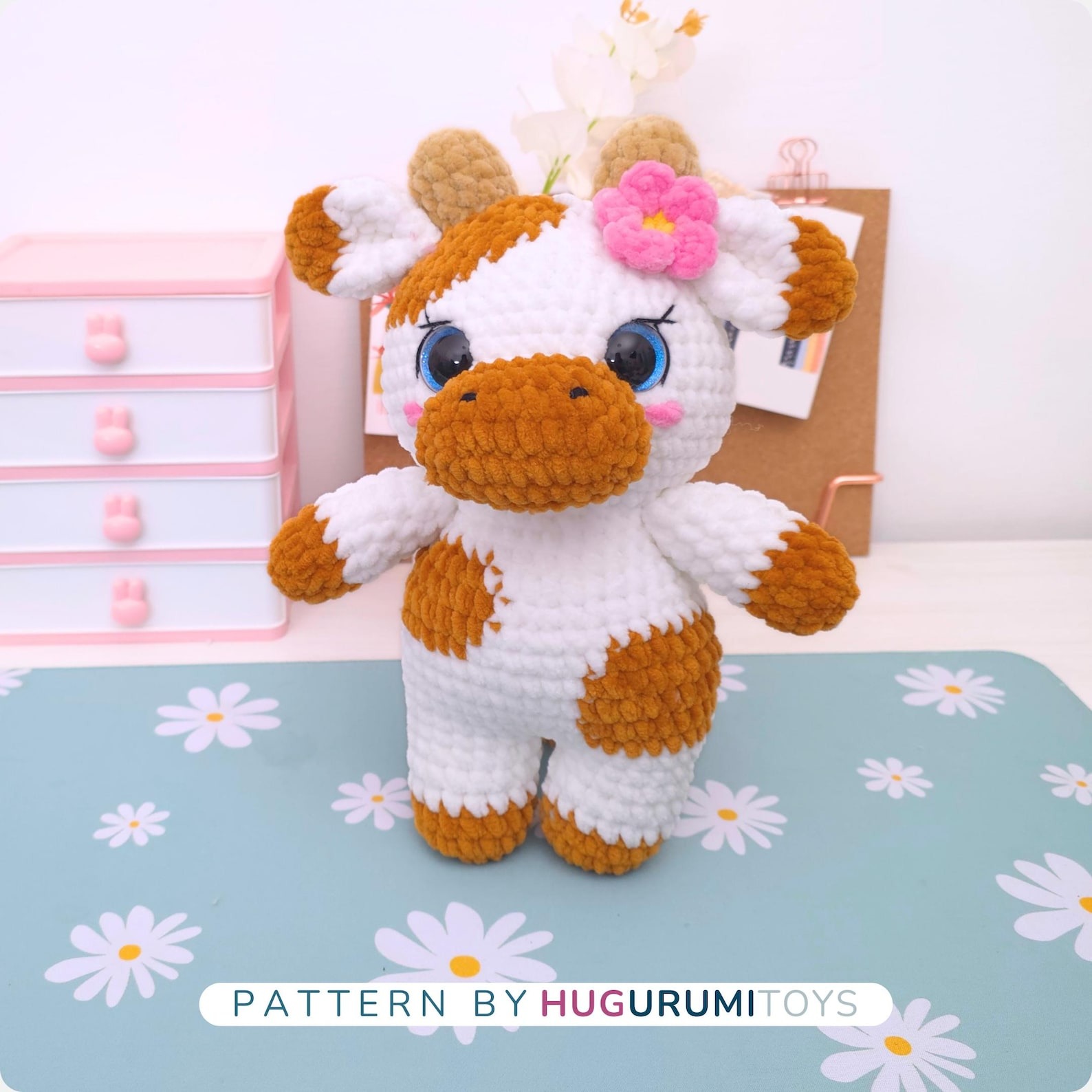 Amigurumi crochet cow wearing blue overalls sitting on a white background – view 4
