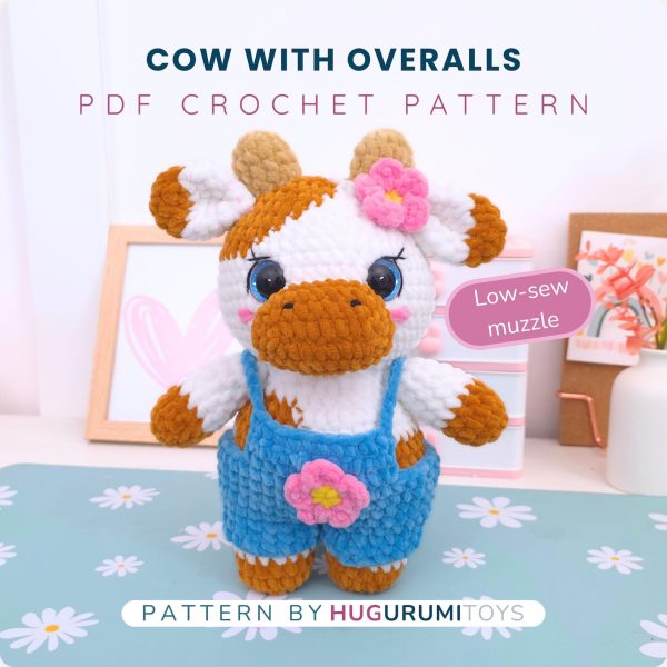 Amigurumi crochet cow wearing blue overalls sitting on a white background